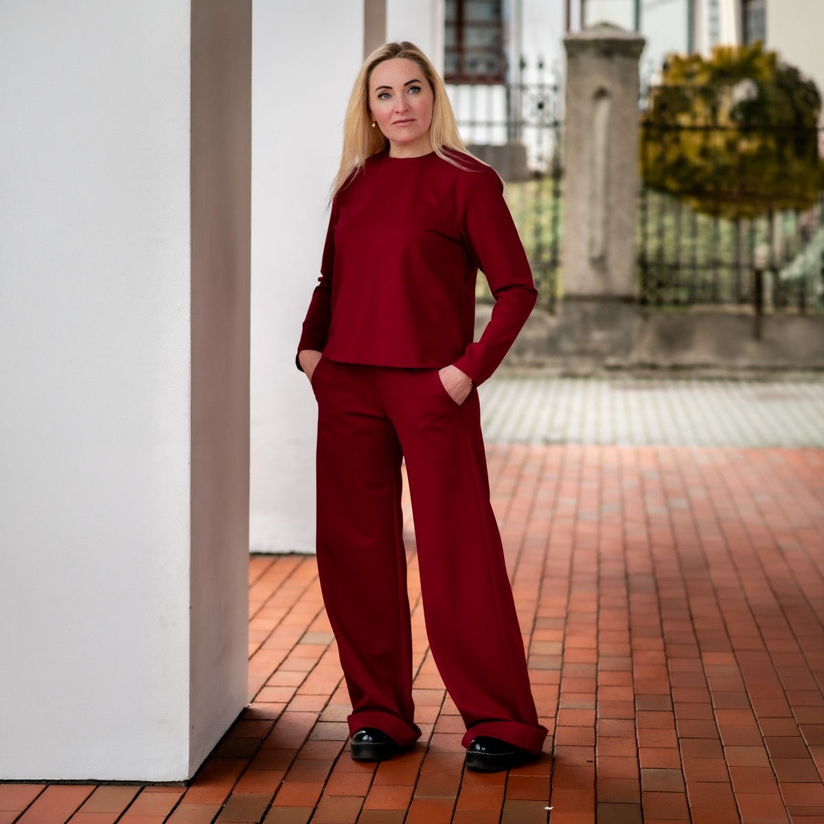 Burgundiškos spalvos laisvalaikio kostiumėlis moterims ELEGANCIJA. Palaidinė apvalia iškirpte ir platėjančios kelnės su kišenėmis.