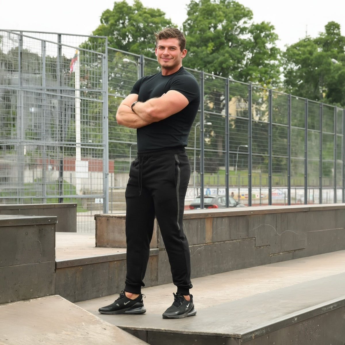 Juodos spalvos laisvalaikio kelnės vyrams PATOGUMAS. Kelnės su pilka juostele, kišenėmis ir patogiu elastiniu juosmeniu.