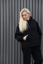 Juodos spalvos laisvalaikio kostiumėlis moterims AUSTĖJA. Džemperis su gobtuvu ir kelnės. Audinys su pūkeliu