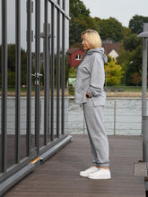 Įkelti vaizdą į galerijos rodinį, Pilkas laisvalaikio kostiumėlis moterims. Džemperis su gobtuvu ir kelnės. 
