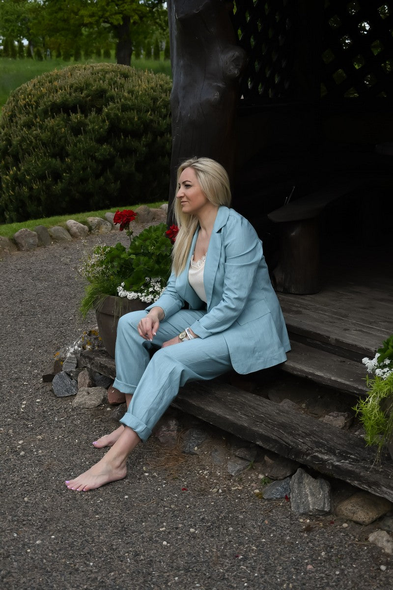 Žydros spalvos lininis kostiumėlis moterims AISTĖ. Elegantiškas, dviejų dalių: klasikinis švarkas ir kelnės su kišenėmis.